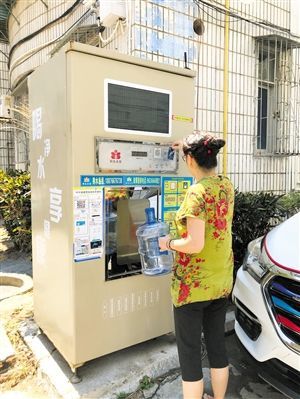 5月24日，瓊山區(qū)上丹花苑小區(qū)居民陳女士在使用共享凈水機(jī)取水。 本報(bào)記者 陳歆卓 攝